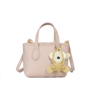 Minimalist light pink lychee pattern bucket bag with a cute monkey bag charm