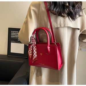 Rote matte Leder-Tote-Bag mit Herz-Detail und kariertem Seidenschal am Modell