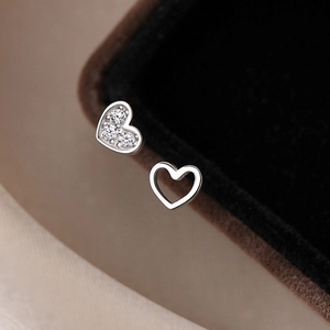 S925 silver asymmetrical heart stud earrings with sparkling cubic zirconia on brown velvet