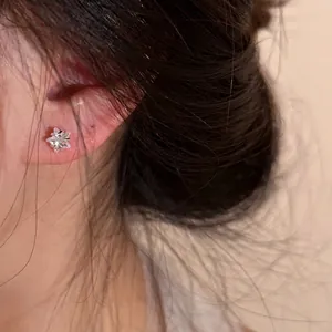 Elegant S925 silver star flower stud earrings with sparkling cubic zirconia on model