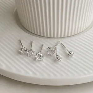Three pairs of minimalist S925 silver star earrings with zircons on white ceramic