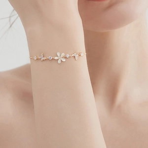 Detail of opal flower bracelet with micro-pave butterfly and bird motifs on model wrist