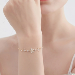 Elegant gold bracelet featuring cat eye flower and crystal butterfly on female wrist