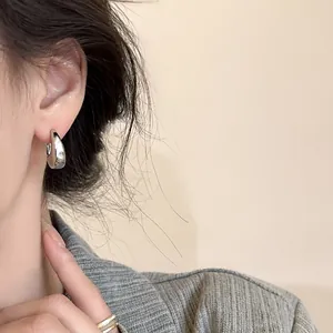 Gros plan de boucles d'oreilles goutte d'eau argentées polies sur un mannequin