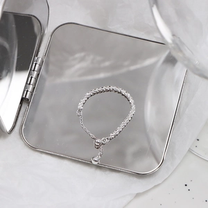 Macro detail of adjustable sparkling silver chain ring with fine beaded sliding closure
