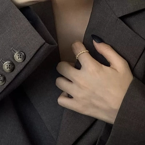 Bague dorée minimaliste à texture irrégulière portée par un mannequin, style moderne chic