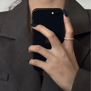 Détail d'une fine bague dorée à texture martelée irrégulière portée sur un doigt