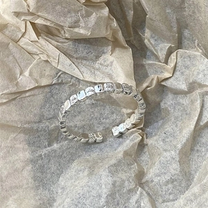 Detailed view of silver minimalist ring featuring unique irregular hammered texture finish