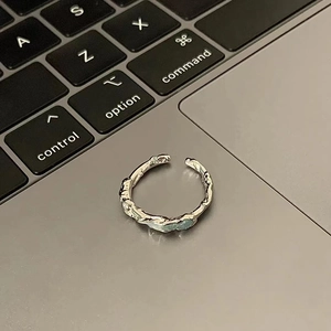Irregular 925 sterling silver ring with molten lava texture on a laptop keyboard