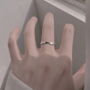 Détail d'une bague géométrique croisée en argent avec finition polie et sablée scintillante