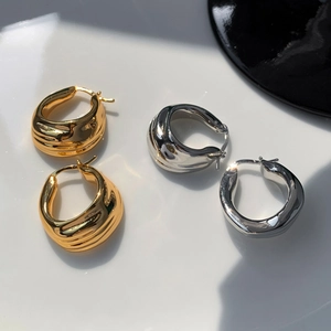 Chunky metallic hoop earrings with irregular fold texture in gold and silver finish