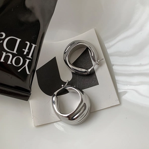 Minimalist silver irregular textured hoop earrings with a polished metallic finish
