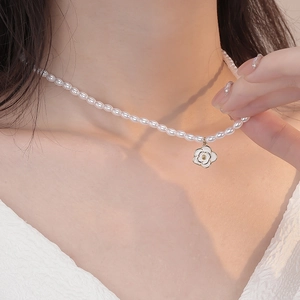 Elegant S925 silver camellia necklace with white pearls on a model neck close-up