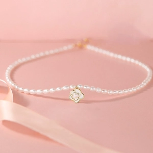 Detailed view of S925 silver camellia flower pendant and lustrous pearl necklace
