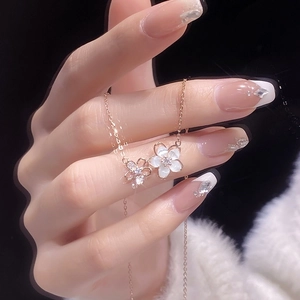 Gros plan sur collier fleur en or rose avec nacre blanche et accents de diamants