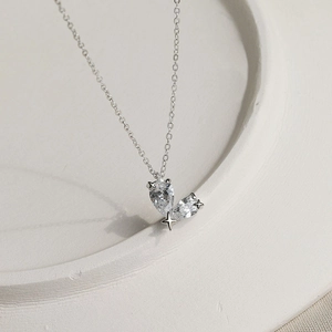 Detail of S925 silver necklace with pear-shaped zircon stones and tiny star charm