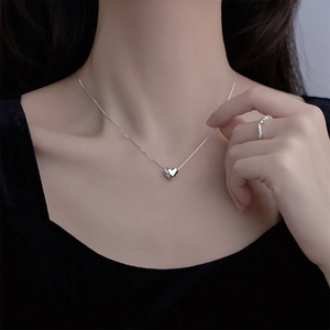 Minimalist silver heart pendant necklace featuring a polished metal finish for women