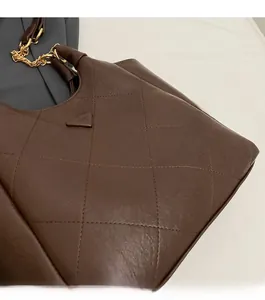 Detail of brown quilted tote bag with gold chain and refined lychee texture leather