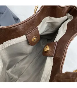 Detail of the magnetic buckle closure and internal grey fabric lining of the tote bag