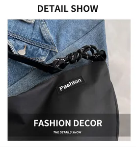 Detail of black nylon crossbody bag with Fashion logo patch and woven rope zipper pull