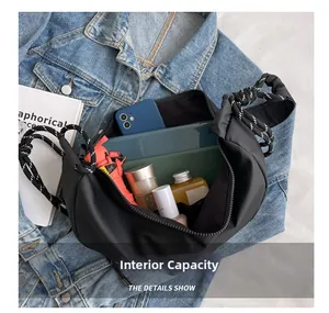 Detail showing internal capacity of black nylon crescent bag with woven strap
