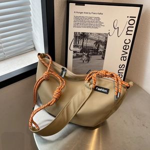 Detail of khaki crescent crossbody bag with orange climbing rope strap and fashion logo