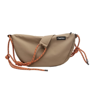 Detail of khaki nylon dumplings bag with orange mountaineering rope strap and pad