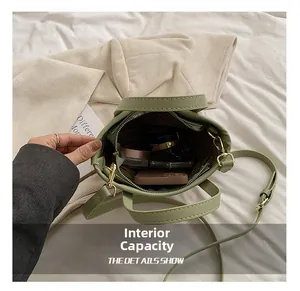 Vue détaillée de l'intérieur du sac vert clair avec rangement pour portable et maquillage