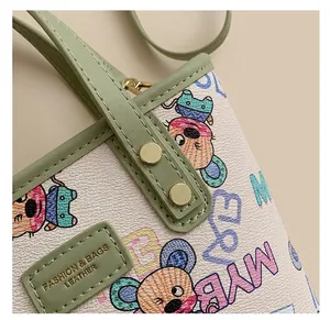 Gros plan du sac en cuir rose avec imprimé souris et rivets sur la poignée verte