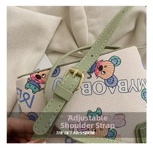 Vue détaillée de la bandoulière réglable en cuir vert avec boucle en métal doré du sac