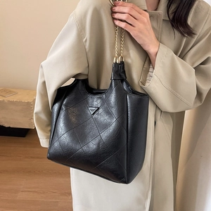 Retro black quilted tote bag with golden chain strap for modern office commuters