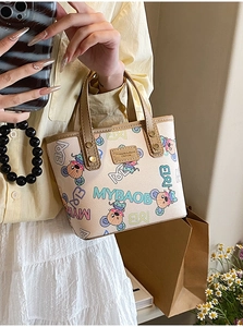 Détail du sac cabas imprimé avec cuir grainé et finitions de rivets dorés élégants