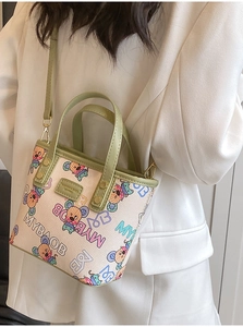 Détail d'un sac cabas chic avec imprimés souris colorés et poignées en cuir vert pour femmes