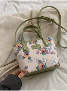 Détail d'un mini sac cabas avec imprimé dessin animé et poignées vertes