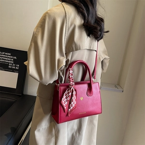 Vintage rote Leder-Tragetasche mit Herzmuster und Seidenschal an einem Modell