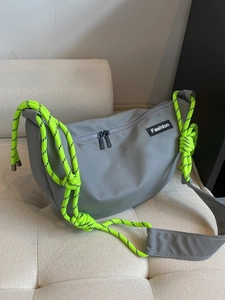 Grey nylon crossbody bag with neon green rope strap and fashion patch on casual sling
