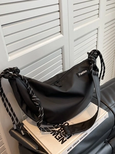 Minimalist black nylon crescent crossbody bag with thick black and white rope shoulder straps