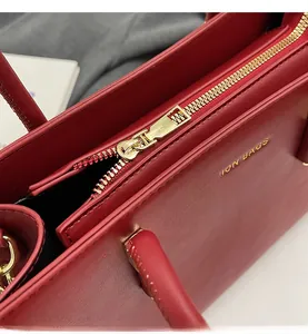 Dettaglio borsa in pelle rossa con cerniera dorata scorrevole e stampa Fashion Bags oro
