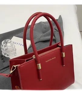 Dettaglio della borsa tote in pelle rossa con scritte FASHION BAGS dorate