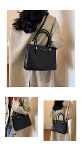 Dettaglio della borsa tote nera in pelle con scritte dorate indossata su un trench beige