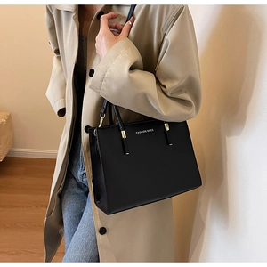 Dettaglio della borsa tote minimalista in pelle nera con scritte dorate Fashion Bags