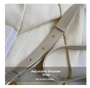 Close-up of adjustable beige leather shoulder strap with gold buckle and fine stitching