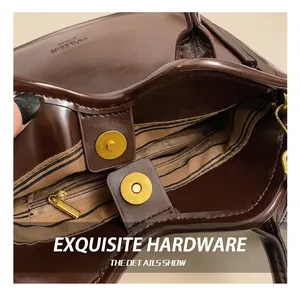 Detail of golden magnetic buckle and zipper with striped lining on brown leather tote