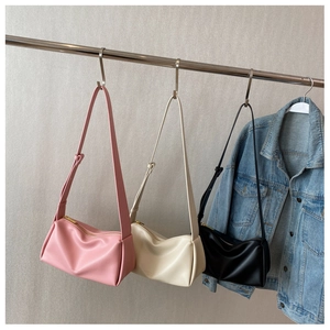 Close-up of minimalist ruched shoulder bags in pink, beige, and black colors