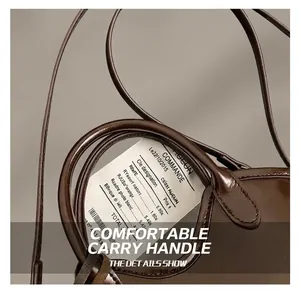 Detail of premium oil wax leather bag handle and slim shoulder strap with glossy finish
