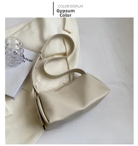 Detail view of stylish beige PU leather underarm bag with smooth texture and logo