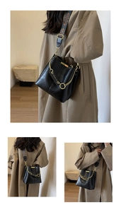 Detail der schwarzen Beuteltasche mit goldener Kette und Vintage-Jacquard-Schultergurt