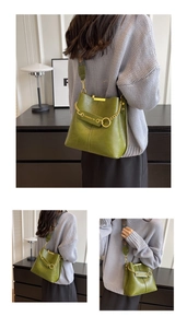 Detailansicht der grünen Beuteltasche mit Goldkette und Logo-Prägung im Design