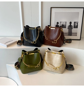 Detailansicht der Eimertaschen mit Metallketten und bedruckten breiten Schultergurten