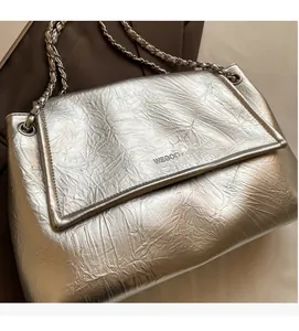 Close-up of the silver metallic crinkled fabric and chain strap on the stylish tote bag